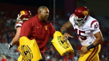 Oct 11, 2014; Tucson, AZ, USA; Southern California Trojans defensive line coach Chris Wilson (left) warms up linebacker Charles Burks (45) against the Arizona Wildcats at Arizona Stadium. Mandatory Credit: Mark J. Rebilas-USA TODAY Sports