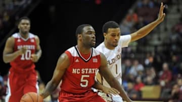 Jan 17, 2015; Tallahassee, FL, USA; North Carolina State Wolfpack guard Desmond Lee (5) handles the ball past Florida State Seminoles guard Devon Bookert (1) during the second half of the game at the Donald L. Tucker Center. Mandatory Credit: Melina Vastola-USA TODAY Sports