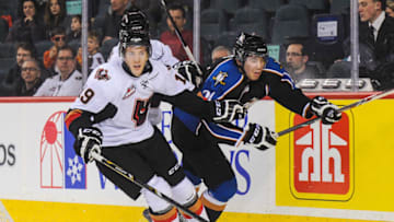CALGARY, AB - MARCH 15: Adam Tambellini #19 of the Calgary Hitmen checks Rinat Valiev #24 of the Kootenay Ice during a WHL game at Scotiabank Saddledome on March 15, 2014 in Calgary, Alberta, Canada. (Photo by Derek Leung/Getty Images)