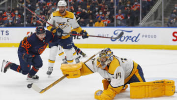 Jan 27, 2022; Edmonton, Alberta, CAN; Nashville Predators goaltender Juuse Saros (74) knocks a loose puck away from Edmonton Oilers forward Kailer Yamamoto (56) during the third period at Rogers Place. Mandatory Credit: Perry Nelson-USA TODAY Sports