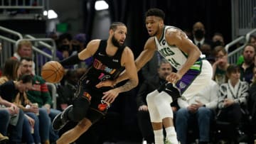 Caleb Martin #16 of the Miami Heat dribbles while being guarded by Giannis Antetokounmpo #34 of the Milwaukee Bucks(Photo by John Fisher/Getty Images)