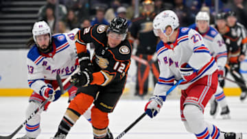 Jan 8, 2022; Anaheim, California, USA; Anaheim Ducks left wing Sonny Milano (12) and New York Rangers center Mika Zibanejad (93) and defenseman Nils Lundkvist (27) battle for the puck in the third period of the game at Honda Center. Mandatory Credit: Jayne Kamin-Oncea-USA TODAY Sports