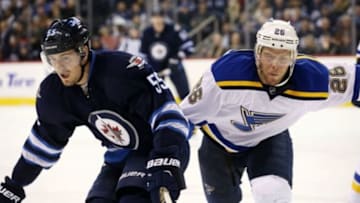Dec 15, 2015; Winnipeg, Manitoba, CAN; Winnipeg Jets center Mark Scheifele (55) battles St. Louis Blues center Paul Stastny (26) during the third period at MTS Centre. St. Louis Blues wins 4-3. Mandatory Credit: Bruce Fedyck-USA TODAY Sports