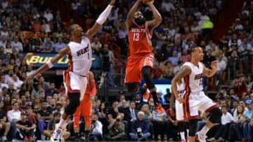 Nov 4, 2014; Miami, FL, USA; Houston Rockets guard James Harden (13) takes a half court shot as Miami Heat forward Chris Bosh (1) defends during the first half at American Airlines Arena. Mandatory Credit: Steve Mitchell-USA TODAY Sports