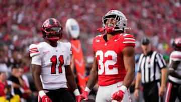 Sep 16, 2023; Columbus, Ohio, USA; Ohio State Buckeyes running back TreVeyon Henderson (32) celebrates a leap over a Western Kentucky Hilltoppers defensive back during the first half of the NCAA football game at Ohio Stadium.