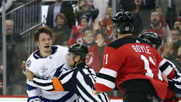 NEWARK, NJ - APRIL 16: A linesman escourts Mikhail Sergachev