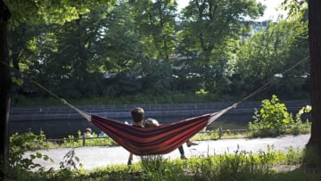 A couple lie in a hammock on the banks of the Landwehr Canal as the sun shines in Berlin's Kreuzberg district on June 1, 2014. Meteorologists forecast temperatures around 20 degrees for the coming days in the capital. AFP PHOTO / DAVID GANNON (Photo credit should read DAVID GANNON/AFP/Getty Images)