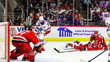 RALEIGH, NC - MARCH 23: Shayne Gostisbehere #41 and Jesperi Kotkaniemi #82 of the Carolina Hurricanes attempt to stop the puck during the third period of the game against the New York Rangers at PNC Arena on March 23, 2023 in Raleigh, North Carolina. Rangers win over Hurricanes 2-1.(Photo by Jaylynn Nash/Getty Images)