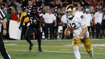 Sep 2, 2019; Louisville, KY, USA; Notre Dame Fighting Irish quarterback Ian Book (12) scores a touchdown against the Louisville Cardinals during the second quarter at Cardinal Stadium. Mandatory Credit: Brian Spurlock-USA TODAY Sports