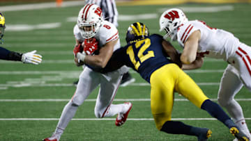 Nov 14, 2020; Ann Arbor, Michigan, USA; Wisconsin Badgers running back Jalen Berger (8) is tackled by Michigan Wolverines linebacker Josh Ross (12) in the second half at Michigan Stadium. Mandatory Credit: Rick Osentoski-USA TODAY Sports