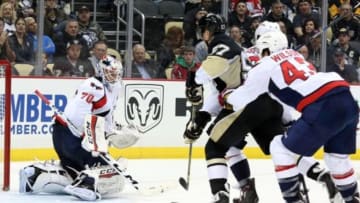 Dec 14, 2015; Pittsburgh, PA, USA; Pittsburgh Penguins left wing David Perron (57) shoots against Washington Capitals goalie Braden Holtby (70) as Caps right wing Tom Wilson (43) defends during the second period at the CONSOL Energy Center. Mandatory Credit: Charles LeClaire-USA TODAY Sports