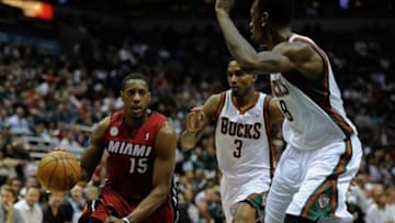 Apr 28, 2013; Milwaukee, WI, USA; Miami Heat guard Mario Chalmers drives for the basket against Milwaukee Bucks guard Brandon Jennings and center Larry Sanders (right) in game four of the first round of the 2013 NBA playoffs at the BMO Harris Bradley Center. Mandatory Credit: Benny Sieu-USA TODAY Sports