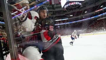 Dec 31, 2015; Raleigh, NC, USA; Carolina Hurricanes defensemen Noah Hanifin (5) checks Washington Capitals forward Jason Chimera (25) during the first period at PNC Arena. Mandatory Credit: James Guillory-USA TODAY Sports