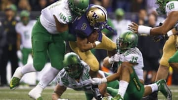 Oct 17, 2015; Seattle, WA, USA; Washington Huskies fullback Myles Gaskin (9) is tackled by Oregon Ducks defensive lineman DeForest Buckner (44), defensive lineman Alex Balducci (56) and linebacker Kaulana Apelu (39) during the second quarter at Husky Stadium. Mandatory Credit: Jennifer Buchanan-USA TODAY Sports