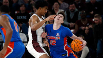 Jan 21, 2023; Starkville, Mississippi, USA; Florida Gators forward Colin Castleton (12) drives to the basket as Mississippi State Bulldogs forward Tolu Smith (1) defends during the second half at Humphrey Coliseum. Mandatory Credit: Petre Thomas-USA TODAY Sports