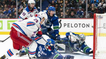 VANCOUVER, BC - NOVEMBER 2: Tucker Poolman #5 of the Vancouver Canucks deflects the shot of Chris Kreider #20 of the New York Rangers wide of the net as goalie Thatcher Demko #35 and J.T. Miller #9 scramble to defend during the third period on November 2, 2021 at Rogers Arena in Vancouver, British Columbia, Canada. (Photo by Rich Lam/Getty Images)