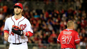 WASHINGTON, DC - APRIL 21: Bryce Harper #34 of the Washington Nationals jogs past Mike Trout #27 of the Los Angeles Angels after Trout lined out for the third out of the seventh inning of the Angels 4-2 winat Nationals Park on April 21, 2014 in Washington, DC. (Photo by Rob Carr/Getty Images)