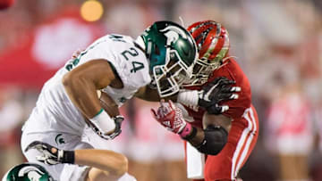 Oct 1, 2016; Bloomington, IN, USA; Michigan State Spartans running back Gerald Holmes (24) is tackled by Indiana Hoosiers linebacker Tegray Scales (8) in the second half of the game at Memorial Stadium. Indiana Hoosiers beat the Michigan State Spartans by the score of 24-21. Mandatory Credit: Trevor Ruszkowski-USA TODAY Sports