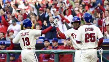 Oct 4, 2015; Philadelphia, PA, USA; Philadelphia Phillies shortstop Freddy Galvis (13) and left fielder Cody Asche (25) celebrate after scoring with third baseman Maikel Franco (7) during the seventh inning against the Miami Marlins at Citizens Bank Park. The Phillies defeated the Marlins, 7-2. Mandatory Credit: Eric Hartline-USA TODAY Sports