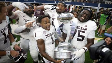 Sep 30, 2023; Arlington, Texas, USA; DUPLICATE***Texas A&M Aggies wide receiver Evan Stewart (1) and offensive lineman Kam Dewberry (75) celebrate with the Southwest Classic trophy after the Aggies victory over the Arkansas Razorbacks at AT&T Stadium. Mandatory Credit: Jerome Miron-USA TODAY Sports