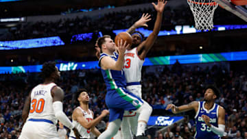 DALLAS, TEXAS - DECEMBER 27: Luka Doncic #77 of the Dallas Mavericks drives to the basket against Mitchell Robinson #23 of the New York Knicks in the second half at American Airlines Center on December 27, 2022 in Dallas, Texas. NOTE TO USER: User expressly acknowledges and agrees that, by downloading and or using this photograph, User is consenting to the terms and conditions of the Getty Images License Agreement. (Photo by Tim Heitman/Getty Images)