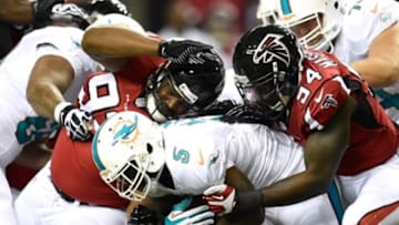 Aug 8, 2014; Atlanta, GA, USA; Atlanta Falcons nose tackle Travian Robertson (92) and defensive end Jonathan Massaquoi (94) tackle Miami Dolphins running back Damien Williams (5) during the second quarter at the Georgia Dome. Mandatory Credit: Dale Zanine-USA TODAY Sports