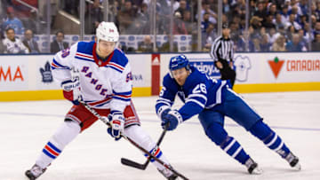 TORONTO, ON - DECEMBER 22: Par Lindholm #26 of the Toronto Maple Leafs battles for the puck against Lias Andersson #50 of the New York Rangers during the first period at the Scotiabank Arena on December 22, 2018 in Toronto, Ontario, Canada. (Photo by Kevin Sousa/NHLI via Getty Images)