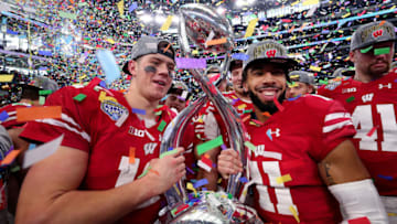 ARLINGTON, TX - JANUARY 02: Alex Hornibrook #12 of the Wisconsin Badgers and Jazz Peavy #11 of the Wisconsin Badgers celebrate with the trophy after the Wisconsin Badgers beat the Western Michigan Broncos 24-16 in the 81st Goodyear Cotton Bowl Classic at AT&T Stadium on January 2, 2017 in Arlington, Texas. (Photo by Tom Pennington/Getty Images)