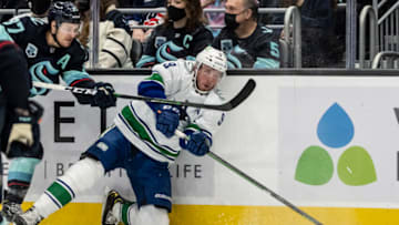 Jan 1, 2022; Seattle, Washington, USA; Vancouver Canucks center J.T. Miller (9) passes the puck as Seattle Kraken center Yanni Gourde(37) defends during the first period at Climate Pledge Arena. Mandatory Credit: Stephen Brashear-USA TODAY Sports