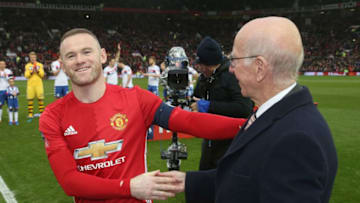 MANCHESTER, ENGLAND - JANUARY 29: Wayne Rooney of Manchester United is presented with a golden boot by Sir Bobby Charlton to mark his 250th Manchester United goal, which saw him break Charlton's club record, ahead of the Emirates FA Cup Fourth Round match between Manchester United and Wigan Athletic at Old Trafford on January 29, 2017 in Manchester, England. (Photo by John Peters/Man Utd via Getty Images)