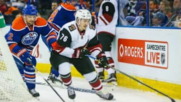 Jan 2, 2016; Edmonton, Alberta, CAN; Arizona Coyotes center Laurent Dauphin (76) and Edmonton Oilers defenseman Andrej Sekera (2) battle for the puck during the second period at Rexall Place. Mandatory Credit: Sergei Belski-USA TODAY Sports