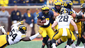 ANN ARBOR, MICHIGAN - OCTOBER 05: Christian Turner #3 of the Michigan Wolverines looks for running room between Daviyon Nixon #54 and Jack Koerner #28 of the Iowa Hawkeyes during a first quarter run at Michigan Stadium on October 05, 2019 in Ann Arbor, Michigan. (Photo by Gregory Shamus/Getty Images)