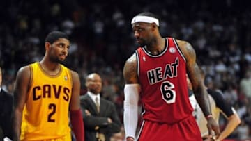Feb 24, 2013; Miami, FL, USA; Cleveland Cavaliers point guard Kyrie Irving (left) looks over at Miami Heat small forward LeBron James (right) as Cleveland Cavaliers head coach Byron Scott (center) looks on during the second half at the American Airlines Arena. MIami won 109-105. Mandatory Credit: Steve Mitchell-USA TODAY Sports