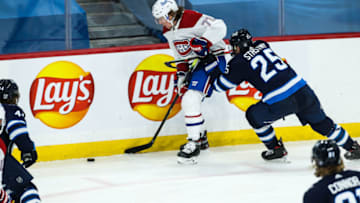 Feb 27, 2021; Winnipeg, Manitoba, CAN; Winnipeg Jets forward Paul Stastny (25) checks Montreal Canadiens forward Tyler Toffoli (73) during the third period at Bell MTS Place. Mandatory Credit: Terrence Lee-USA TODAY Sports