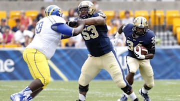 Aug 30, 2014; Pittsburgh, PA, USA; Pittsburgh Panthers running back Isaac Bennett (34) rushes the ball as Panthers offensive linesman Dorian Johnson (53) blocks Delaware Fightin Blue Hens defensive lineman Josh Plummer (58) during the first quarter against at Heinz Field. PITT won 62-0. Mandatory Credit: Charles LeClaire-USA TODAY Sports