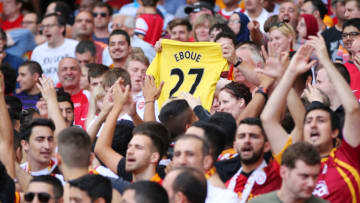 An Arsenal fan holds up a shirt with Eboue written on it (Photo by AMA/Corbis via Getty Images)