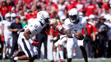 LOUISVILLE, KENTUCKY - OCTOBER 05: Micale Cunningham #3 of the Louisville Cardinals hands the ball off to Javian Hawkins #10 in the game against the Boston College Eagles during the second quarter at Cardinal Stadium on October 05, 2019 in Louisville, Kentucky. (Photo by Justin Casterline/Getty Images)