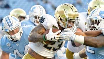 CHAPEL HILL, NORTH CAROLINA - NOVEMBER 27: Kyren Williams #23 of the Notre Dame Fighting Irish runs against Jahlil Taylor #52 of the North Carolina Tar Heels during the first half of their game at Kenan Stadium on November 27, 2020 in Chapel Hill, North Carolina. (Photo by Grant Halverson/Getty Images)