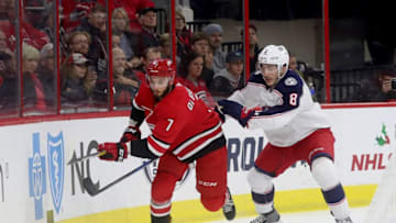 RALEIGH, NC - NOVEMBER 17: Phillip DiGiuseppe #7 of the Carolina Hurricanes battles along the boards with Zach Werenski #8 of the Columbus Blue Jackets during an NHL game on November 17, 2018 at PNC Arena in Raleigh, North Carolina. (Photo by Gregg Forwerck/NHLI via Getty Images)