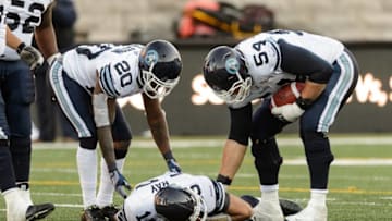 MONTREAL, QC - NOVEMBER 2: Steve Slaton #20 and Chris Van Zeyl #54 checks on teammate Ricky Ray #15 of the Toronto Argonauts during the CFL game against the Montreal Alouettes at Percival Molson Stadium on November 2, 2014 in Montreal, Quebec, Canada. The Montreal Alouettes defeated the Toronto Argonauts 17-14. (Photo by Minas Panagiotakis/Getty Images)