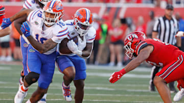 Aug 31, 2023; Salt Lake City, Utah, USA; Florida Gators running back Trevor Etienne (7) runs the ball with help from tight end Dante Zanders (18) in the first half at Rice-Eccles Stadium. Mandatory Credit: Jeff Swinger-USA TODAY Sports