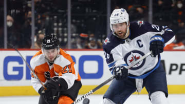 PHILADELPHIA, PENNSYLVANIA - FEBRUARY 01: Scott Laughton #21 of the Philadelphia Flyers and Blake Wheeler #26 of the Winnipeg Jets challenge for the puck during the third period at Wells Fargo Center on February 01, 2022 in Philadelphia, Pennsylvania. (Photo by Tim Nwachukwu/Getty Images)