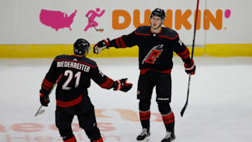 RALEIGH, NORTH CAROLINA - MARCH 04: Nino Niederreiter #21 of the Carolina Hurricanes celebrates with teammate Martin Necas #88 following an empty-net goal by Niederreiter during the third period of their game against the Detroit Red Wings at PNC Arena on March 04, 2021 in Raleigh, North Carolina. (Photo by Jared C. Tilton/Getty Images)
