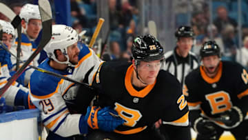 BUFFALO, NY - OCTOBER 22: Brandon Carlo #25 of the Boston Bruins checks Vinnie Hinostroza #29 of the Buffalo Sabres during the second period at KeyBank Center on October 22, 2021 in Buffalo, New York. (Photo by Kevin Hoffman/Getty Images)