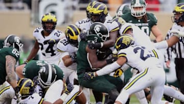 EAST LANSING, MI - OCTOBER 20: LJ Scott #3 of the Michigan State Spartans is tackled by the Michigan Wolverines defense during a second half run at Spartan Stadium on October 20, 2018 in East Lansing, Michigan. Michigan won the game 21-7. (Photo by Gregory Shamus/Getty Images)