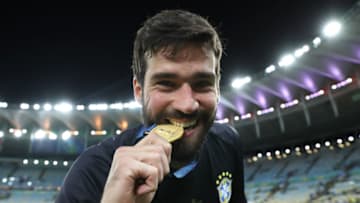 RIO DE JANEIRO, BRAZIL - JULY 07: Alisson Becker of Brazil bites his champion medal after winning the Copa America Brazil 2019 Final match between Brazil and Peru at Maracana Stadium on July 07, 2019 in Rio de Janeiro, Brazil. (Photo by Buda Mendes/Getty Images)