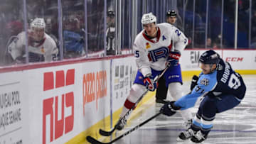 LAVAL, QC - NOVEMBER 15: Michael McCarron #25 of the Laval Rocket plays the puck near Laurent Dauphin #91 of the Milwaukee Admirals during the second period at Place Bell on November 15, 2019 in Laval, Canada. (Photo by Minas Panagiotakis/Getty Images)