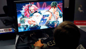 PARIS, FRANCE - FEBRUARY 18: A kid plays a video game "Street Fighter" developed by Capcom during an electronic video game tournament at the eSports World Convention (ESWC) on February 18, 2017 in Paris, France. The ESWC is the historic and emblematic event of electronic sports, bringing together every year since 2003 the best players in the world in video game tournaments designed as real live shows and broadcast live on the Internet or on television. 20 of the biggest American teams of Call of Duty will be present to compete in the tournament CWL Paris Open. Never had an event organized in Europe so much engaged the American eSport community. (Photo by Chesnot/Getty Images)