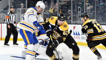 May 1, 2021; Boston, Massachusetts, USA; Boston Bruins center Sean Kuraly (52) tries to gain control of the puck while Buffalo Sabres defenseman Rasmus Dahlin (26) defends during the second period at TD Garden. Mandatory Credit: Bob DeChiara-USA TODAY Sports