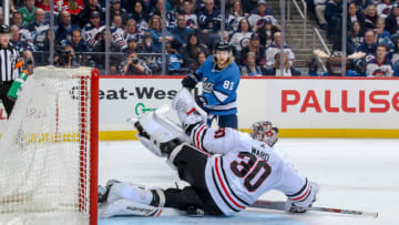 WINNIPEG, MB - DECEMBER 11: Goaltender Cam Ward #30 of the Chicago Blackhawks makes a glove save on Kyle Connor #81 of the Winnipeg Jets during second period action at the Bell MTS Place on December 11, 2018 in Winnipeg, Manitoba, Canada. (Photo by Jonathan Kozub/NHLI via Getty Images)
